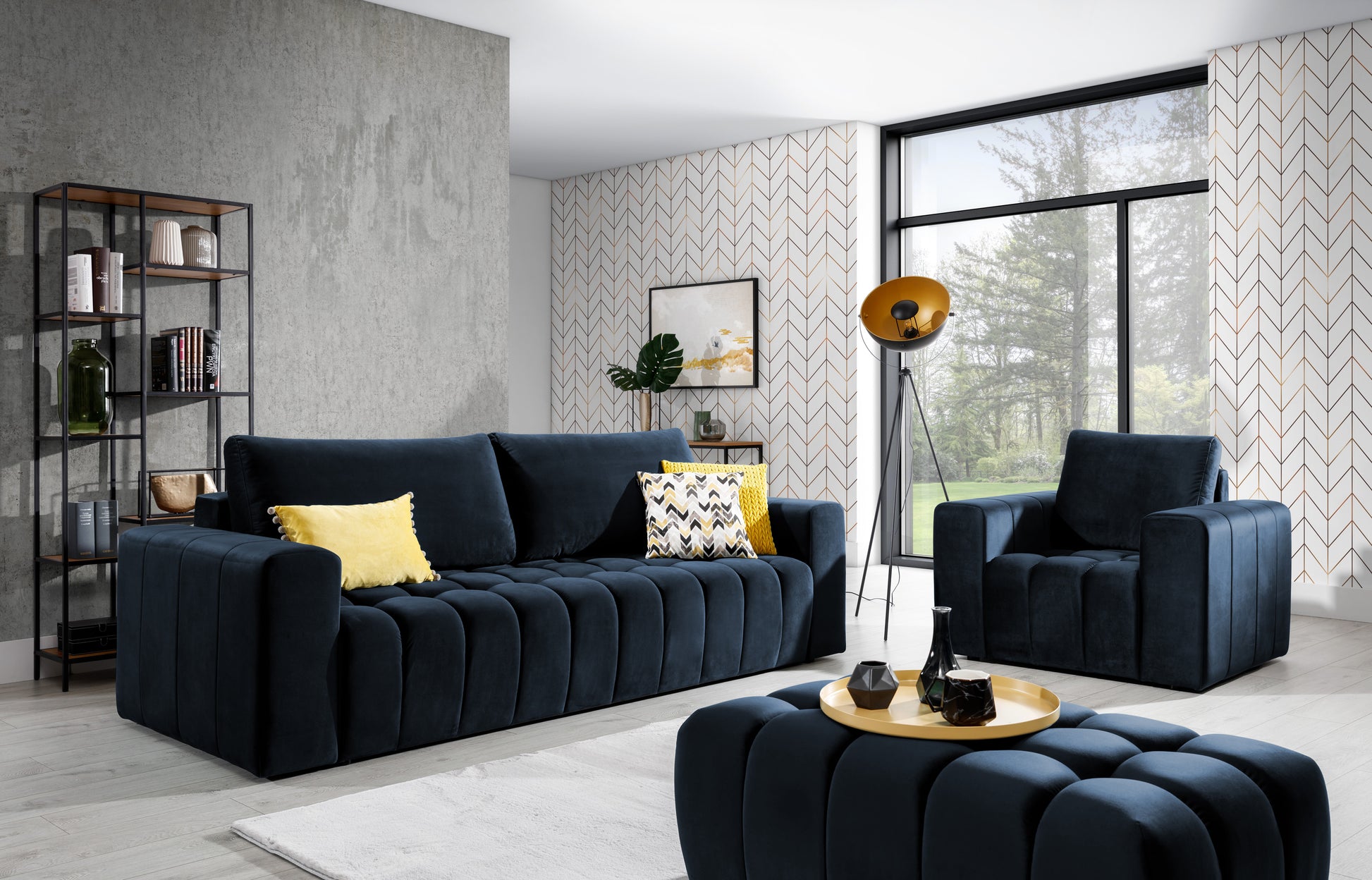 Zestaw mebli wypoczynkowych Lazaro w kolorze Monolith 79 granatowy w stylowym salonie z dużymi oknami – sofa, fotel i pufa na tle jasnych ścian z geometryczną tapetą i minimalistycznym wystrojem.