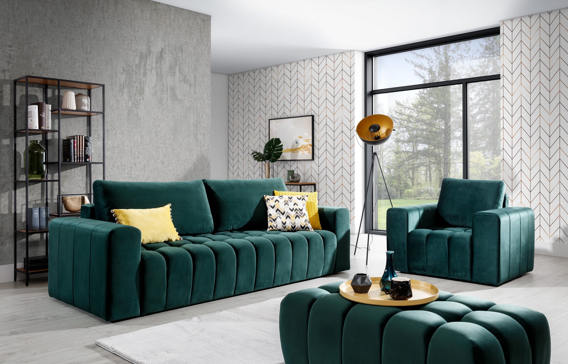 Zestaw wypoczynkowy Lazaro w kolorze Monolith 37 zielony w jasnym salonie z dużym oknem, tapetą w jodełkę i loftowymi dodatkami. Komplet tworzą sofa, fotel i pufa, uzupełnione o żółte i wzorzyste poduszki.