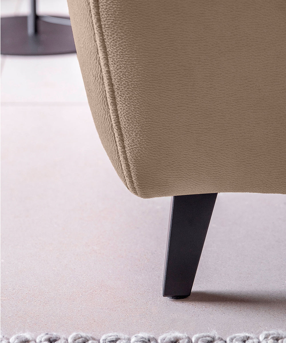 Detal narożnika Noble Nube 20 ukazujący zaokrąglone wykończenie oraz strukturę tkaniny w odcieniu cappuccino. Designerski narożnik wypoczynkowy do nowoczesnych, minimalistycznych i eleganckich wnętrz salonowych.