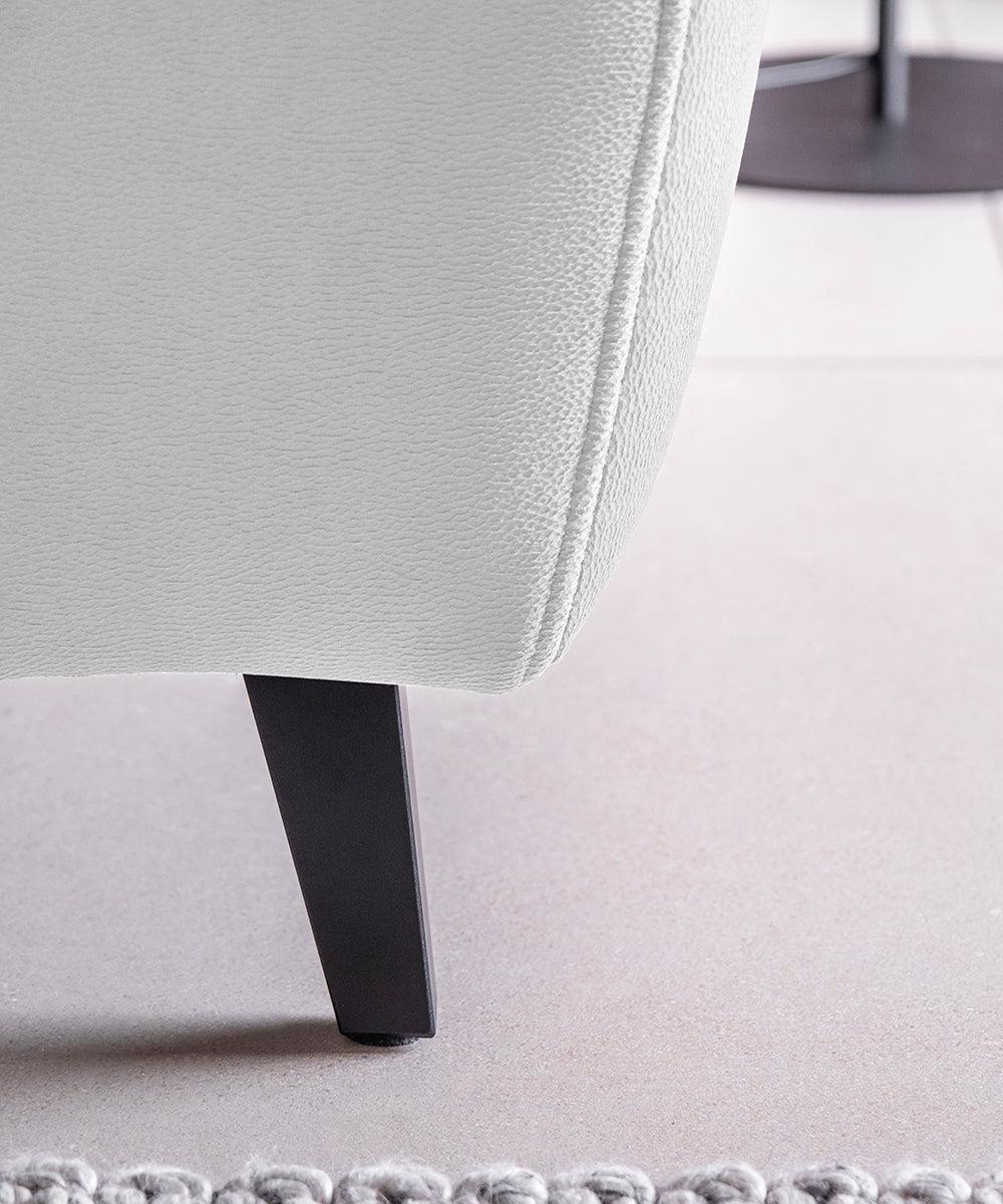 Biały narożnik Noble Savoi 01 z otwartym pojemnikiem na pościel oraz regulowanymi zagłówkami w nowoczesnym salonie. Funkcjonalny narożnik wypoczynkowy do eleganckich i minimalistycznych wnętrz rodzinnych.