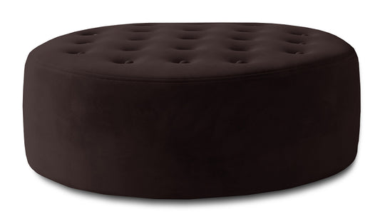 Brązowa pufa Monty w tkaninie Monolith 29 pokazana jako okrągły mebel tapicerowany z miękkim siedziskiem, dekoracyjnym pikowaniem i elegancką strukturą materiału.