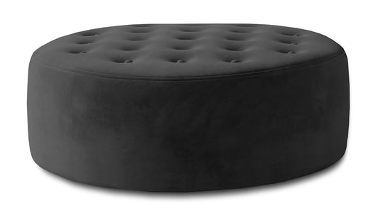 Ciemnoszara pufa Monty w tkaninie Monolith 97 pokazana jako okrągły mebel tapicerowany z miękkim siedziskiem, dekoracyjnym pikowaniem i elegancką strukturą materiału.