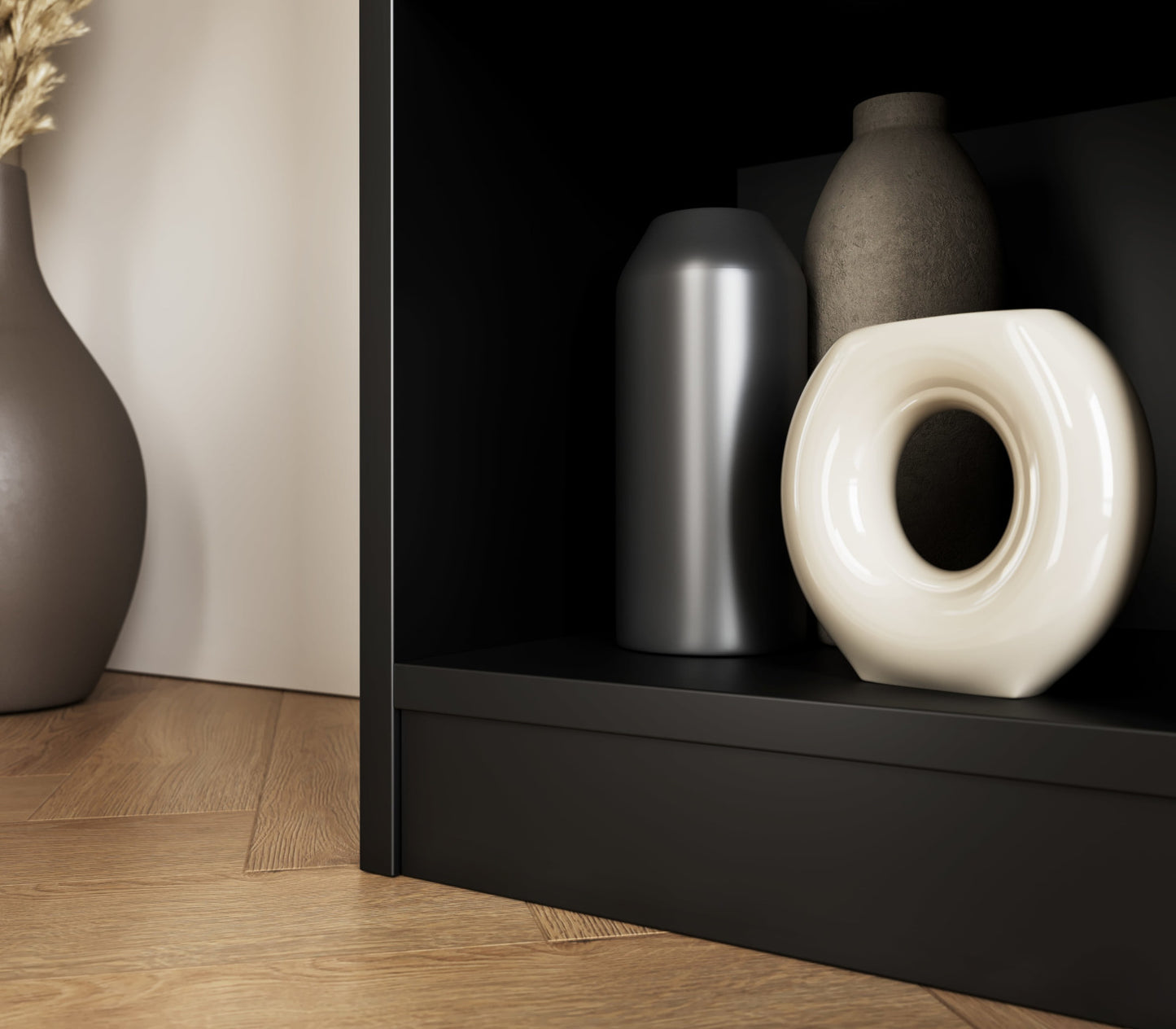 Detale dolnej półki regału Craft w czarnym wykończeniu z dekoracjami ceramicznymi i wazonem