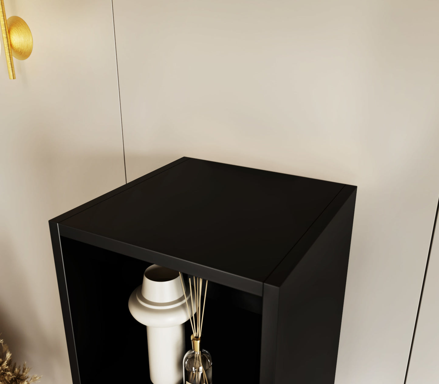 Zbliżenie górnej półki czarnego regału Craft z ozdobnym wazonem na tle jasnej ściany