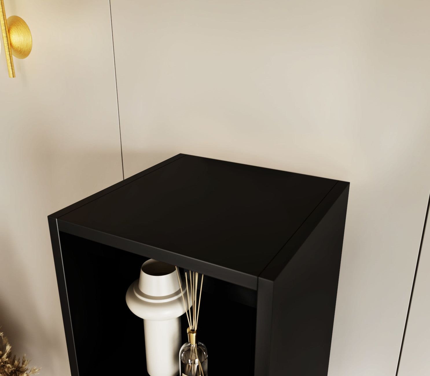Zbliżenie górnej półki czarnego regału Craft z ozdobnym wazonem na tle jasnej ściany