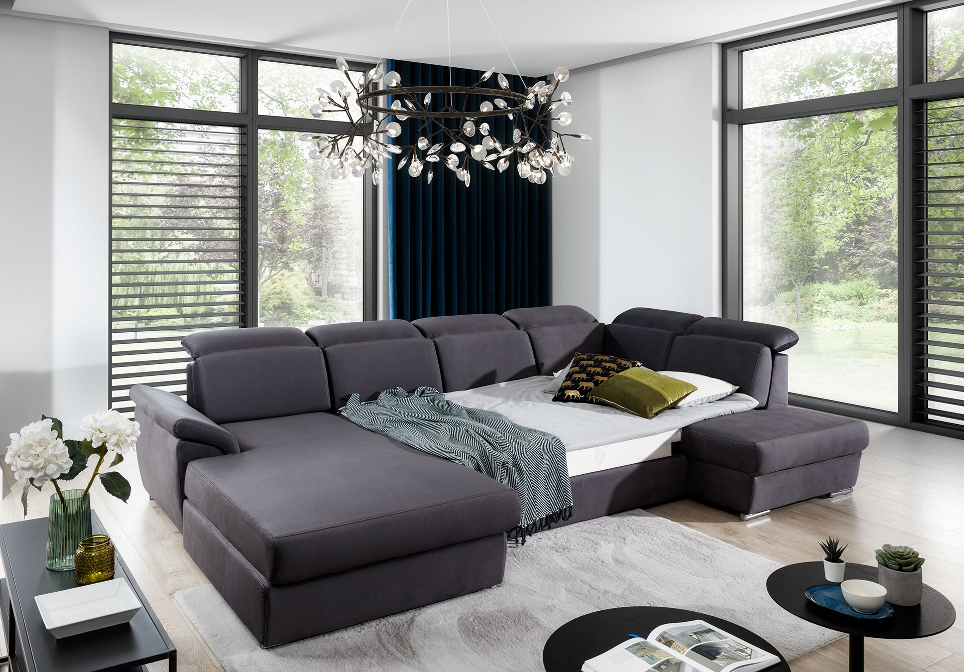 Ciemnoszary narożnik do salonu Evanell Monolith 97 łączy nowoczesny design z funkcjonalnością, oferując wygodne miejsce do relaksu, miękkie poduszki oraz estetyczne wykończenie pasujące do różnych stylów wnętrz