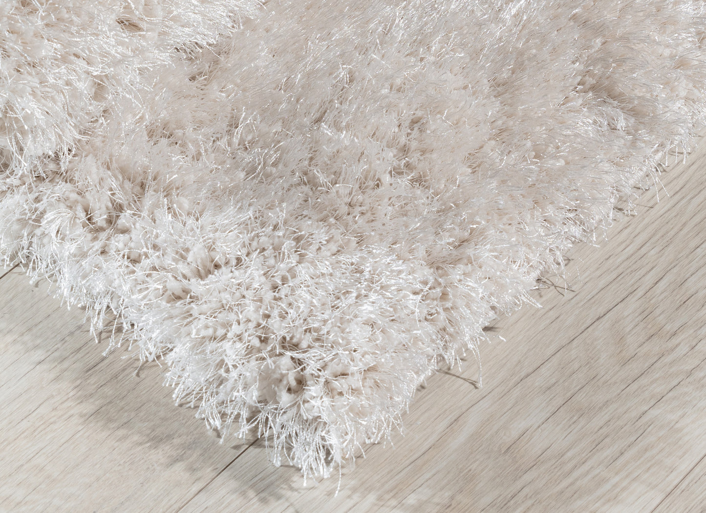 Detal dywanu Blodwen Beige 120x180 cm z widocznym gęstym splotem i delikatnym połyskiem włosia.