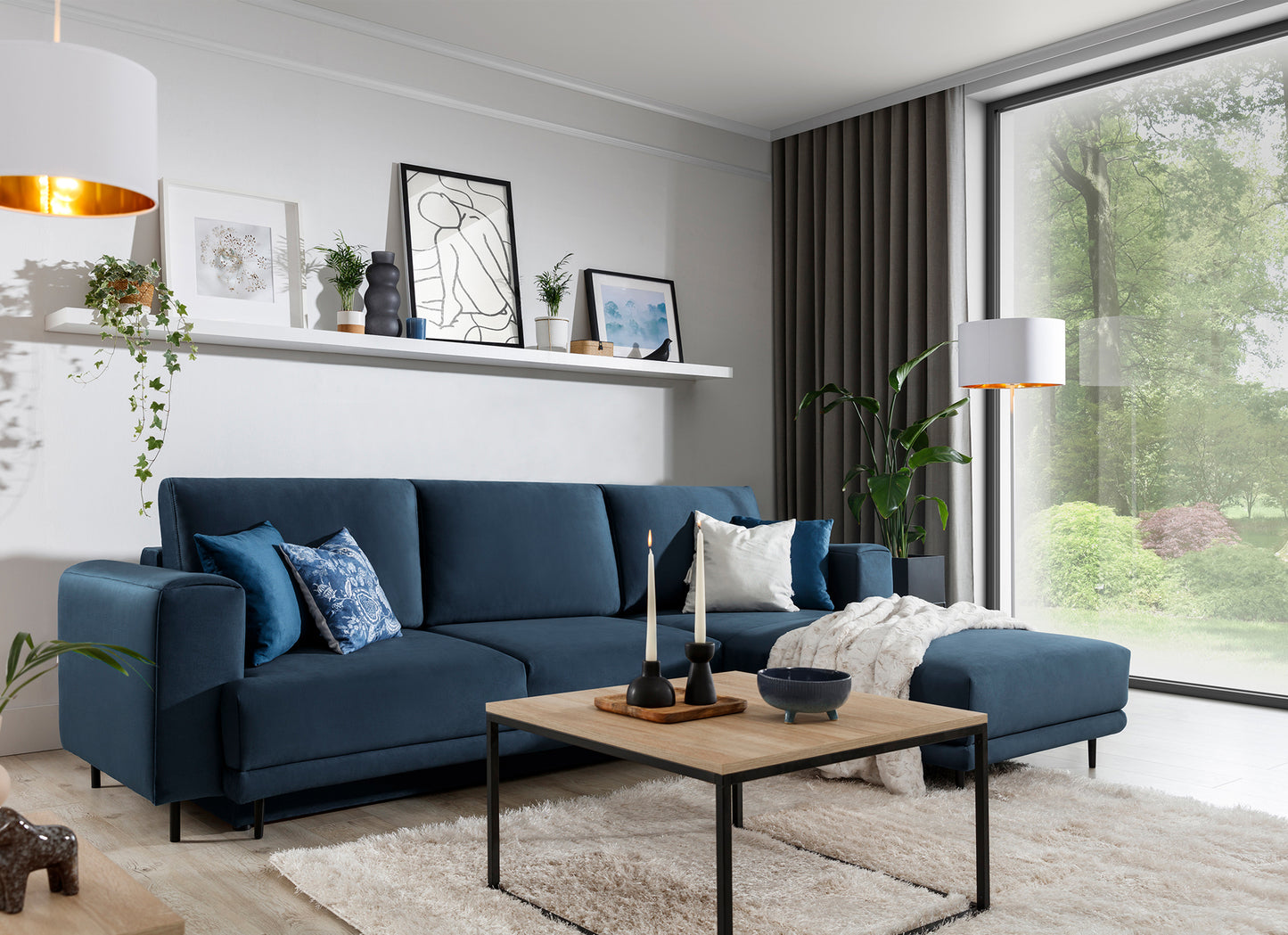 Dywan Blodwen Beige 80x150 cm w nowoczesnym salonie z granatową sofą narożną i drewnianym stolikiem.