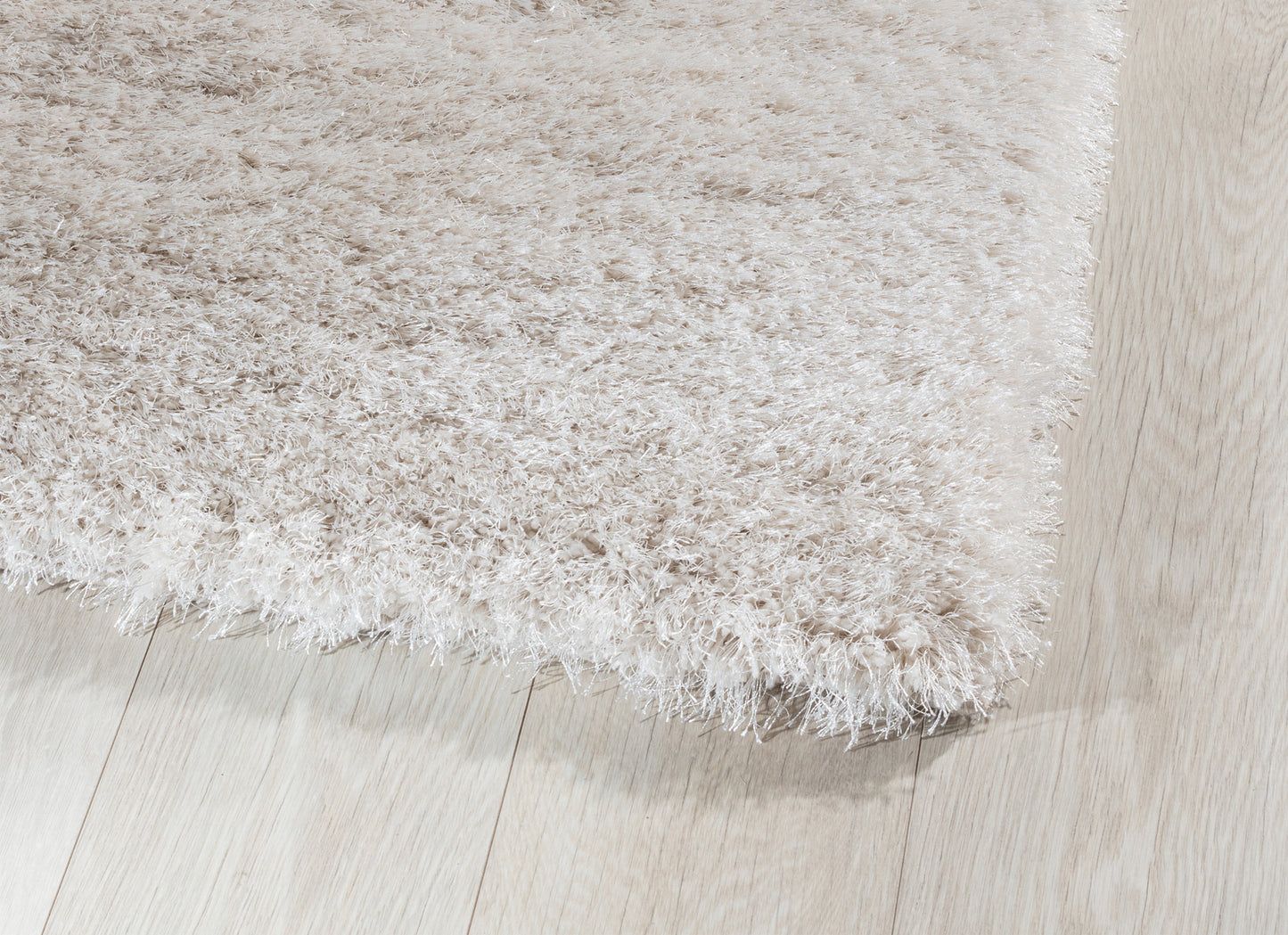 Detal dywanu Blodwen Beige 80x150 cm z widocznym gęstym splotem i wysokim, sprężystym włosiem.