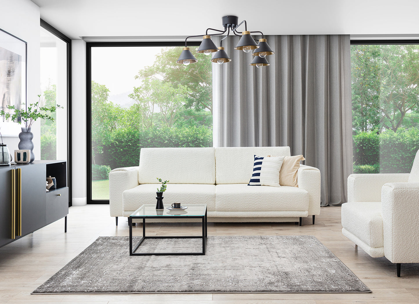 Dywan Codrila Grey 80x150 cm w jasnym salonie z białą sofą i dużymi oknami, w nowoczesnej aranżacji.