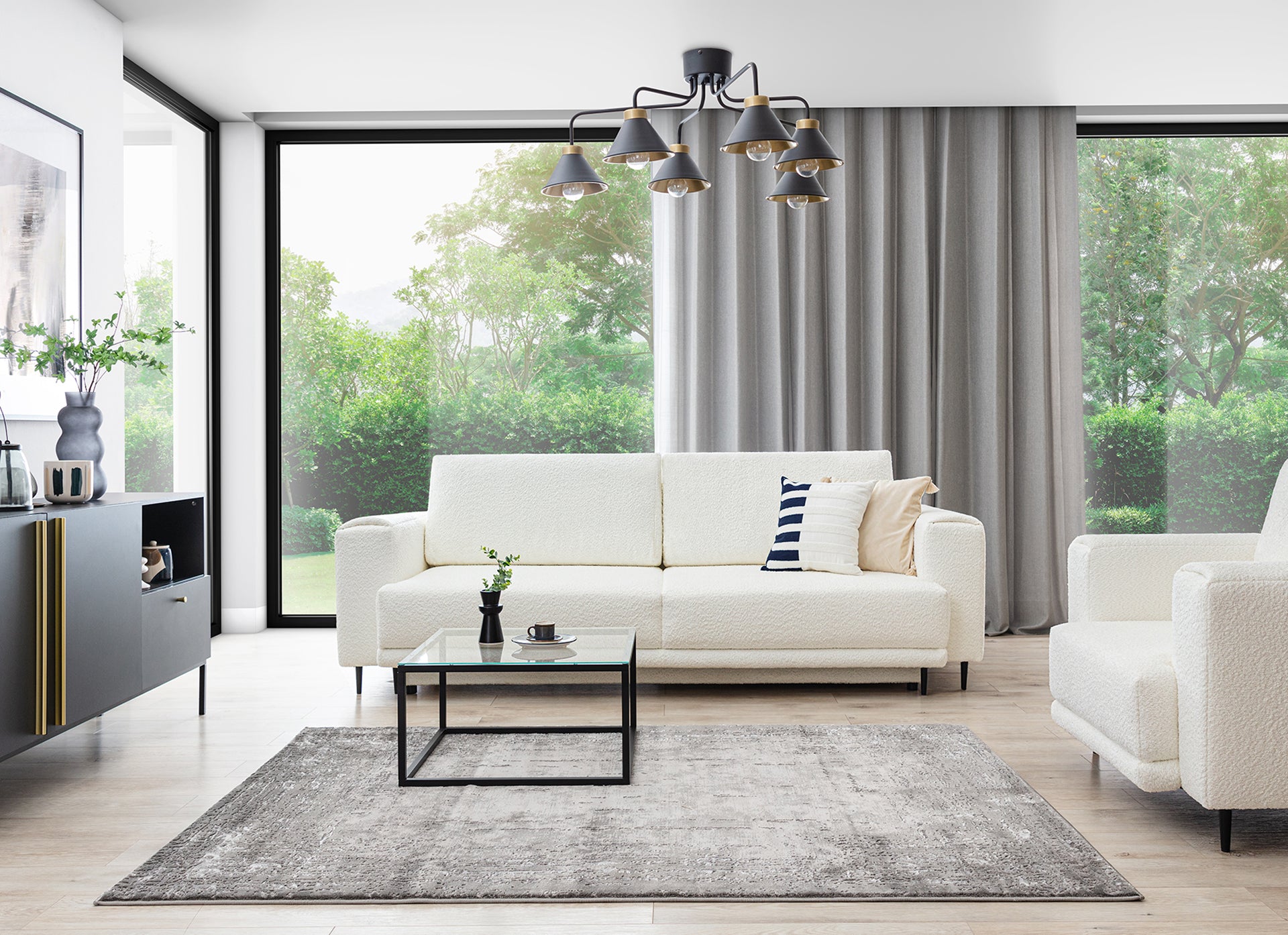 Dywan Codrila Grey 80x150 cm w jasnym salonie z białą sofą i dużymi oknami, w nowoczesnej aranżacji.