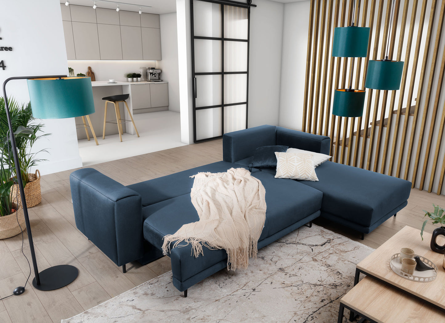Dywan Collymore Beige 160x230 cm w aranżacji salonu z rozłożonym narożnikiem w kolorze granatowym i jasnym pledem – widok z góry.
