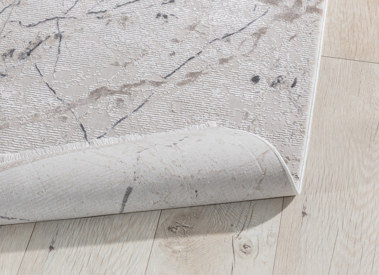 Dywan Collymore Beige 160x230 cm – zbliżenie na narożnik z lekko podwiniętą krawędzią, pokazujące strukturę i grubość materiału.