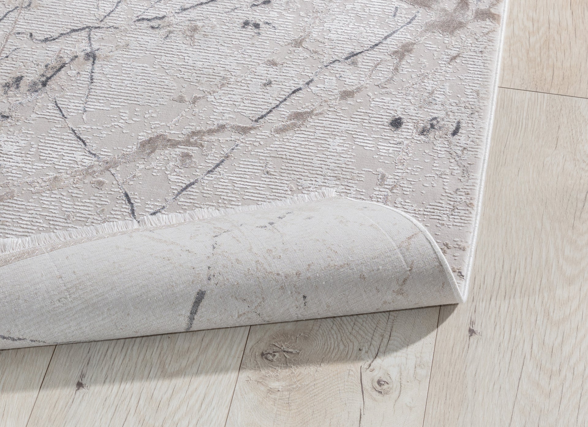 Dywan Collymore Beige 160x230 cm – zbliżenie na narożnik z lekko podwiniętą krawędzią, pokazujące strukturę i grubość materiału.