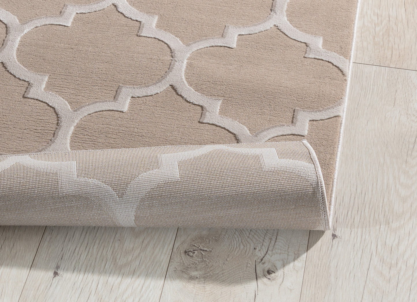 Dywan Elsher Beige 120x180 cm z lekko podwiniętą krawędzią – widoczna elastyczność i precyzyjne wykonanie spodniej warstwy.