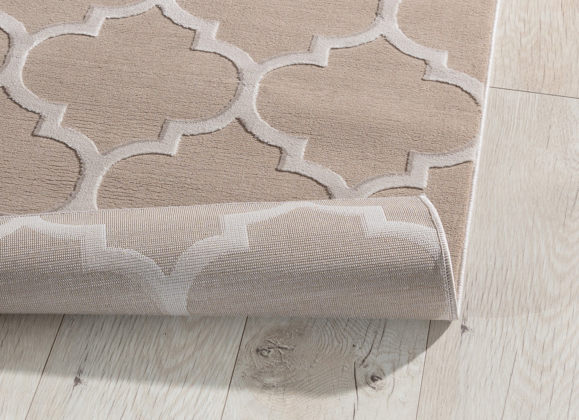 Dywan Elsher Beige 80x150 cm z lekko podwiniętą krawędzią – prezentacja faktury i spodu tkaniny.