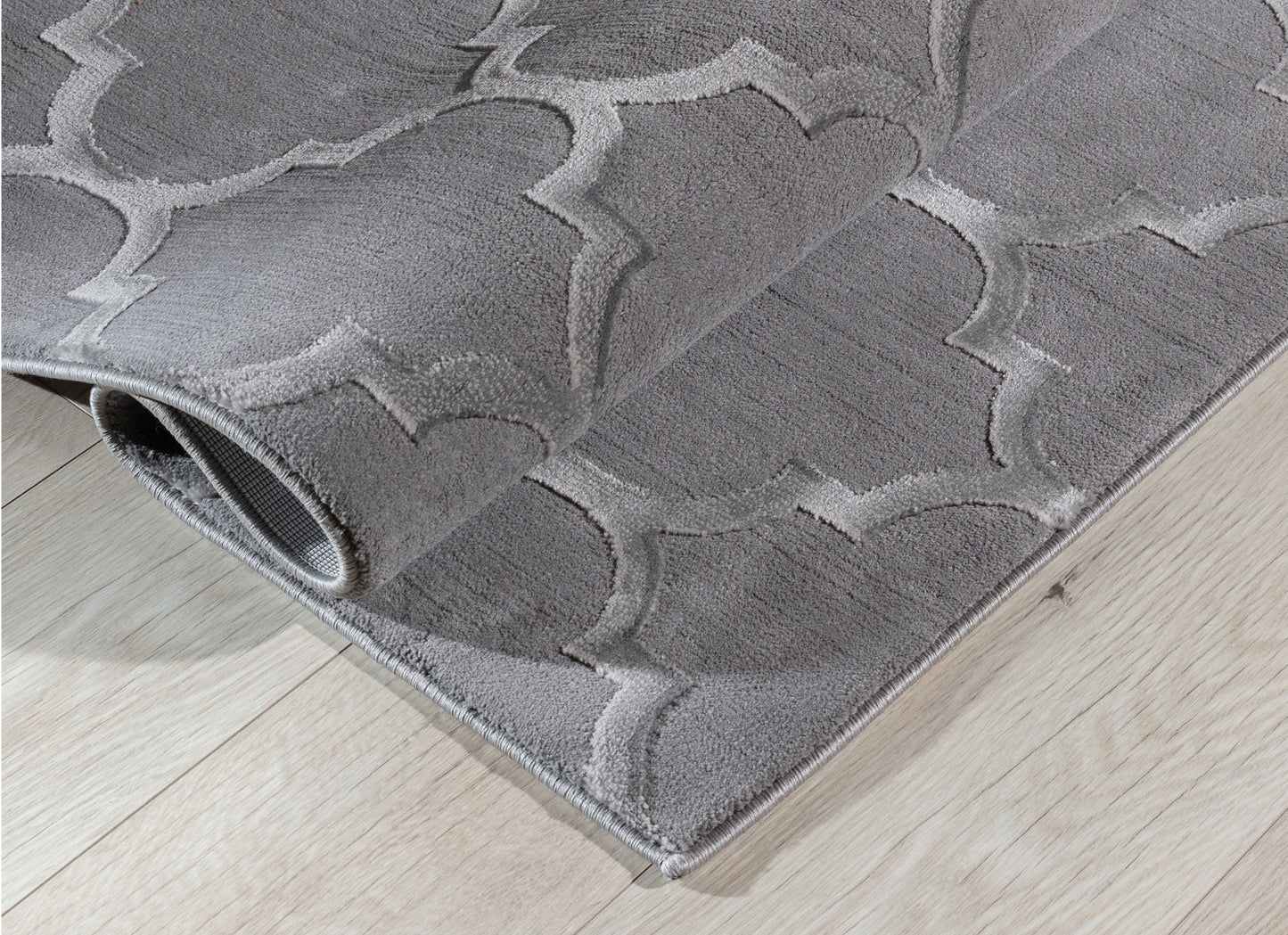 Dywan Elsher Grey 160x220 cm zwinięty w rulon, prezentujący grubość, fakturę i elegancki geometryczny wzór w odcieniach szarości.