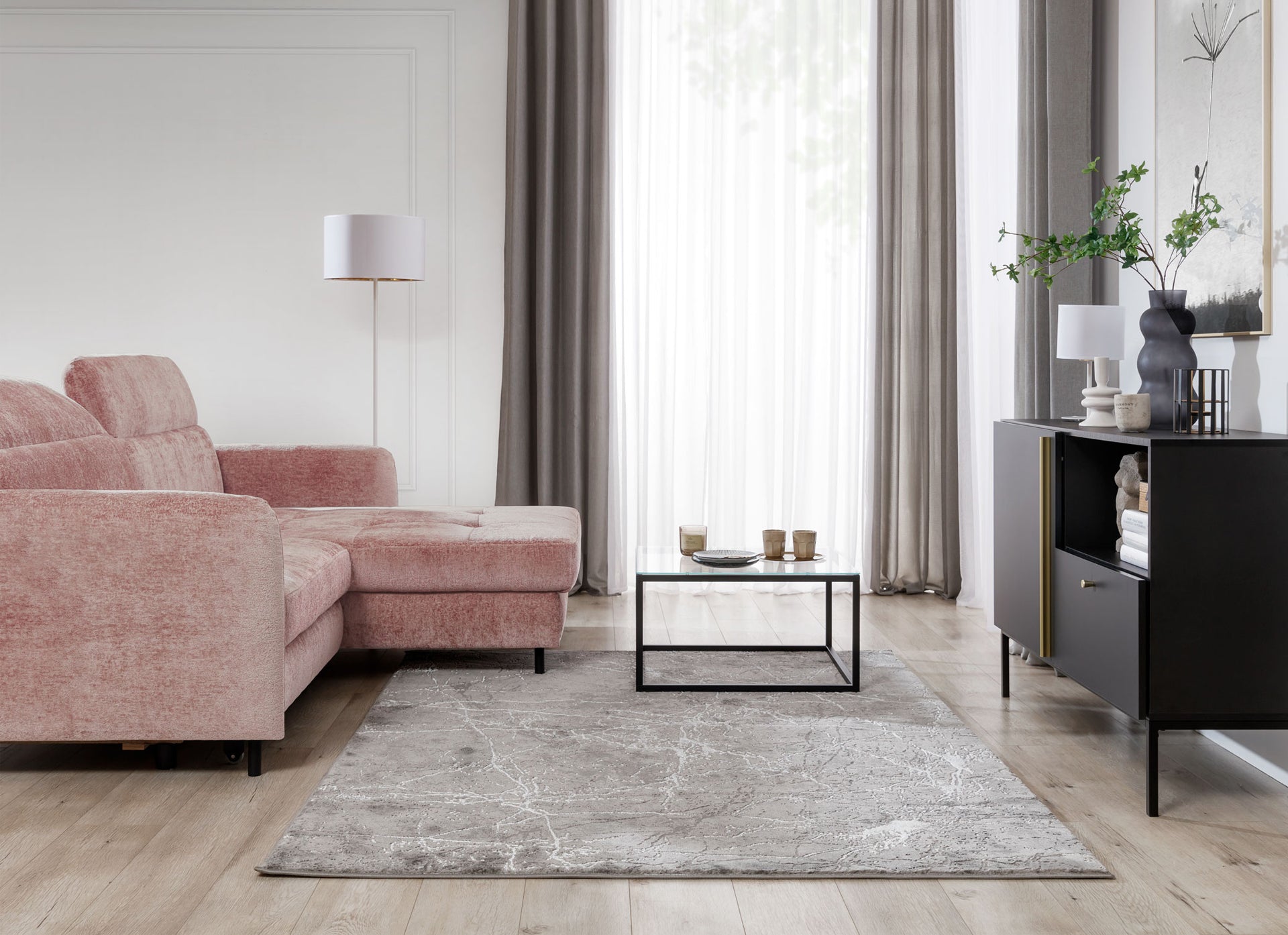 Dywan Siggi Grey 80x150 cm w nowoczesnym salonie z różową sofą, czarną komodą i stolikiem z metalową ramą – elegancka aranżacja wnętrza.