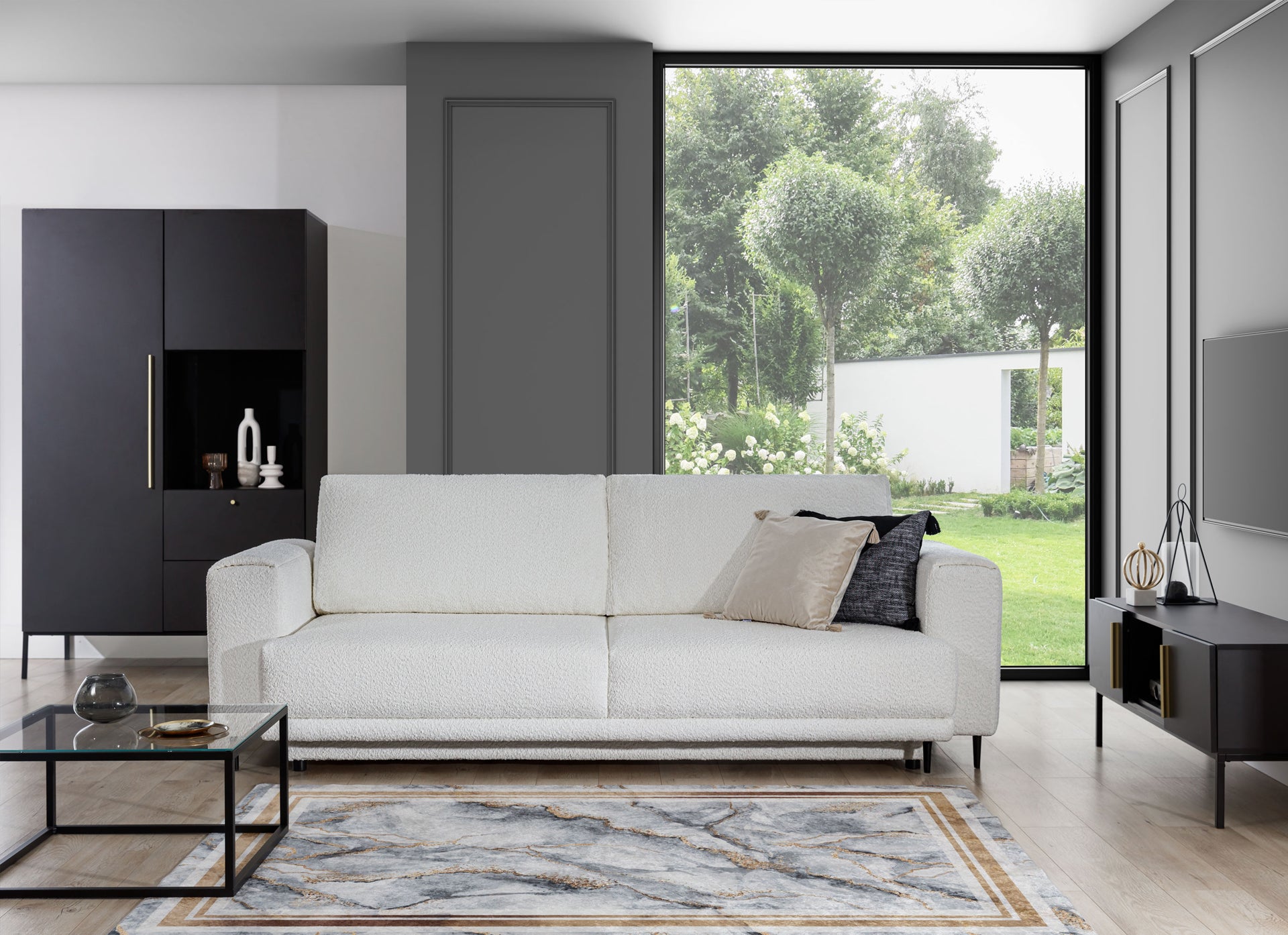 Dywan Squitta Grey 80x150 cm w nowoczesnym wnętrzu z białą sofą i dużym oknem – stylowa dekoracja w odcieniach szarości i złota.