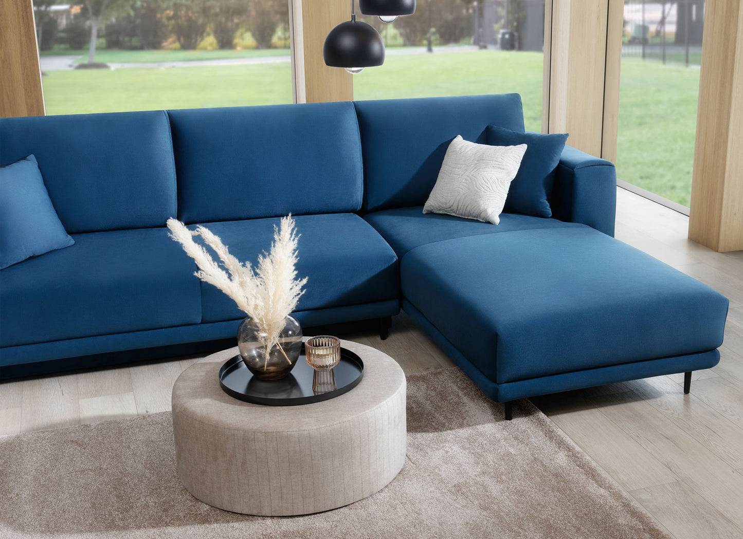 Dywan Verlice Beige 160x230 cm w salonie z granatowym narożnikiem i beżowym pufem – elegancki akcent w nowoczesnym wnętrzu.