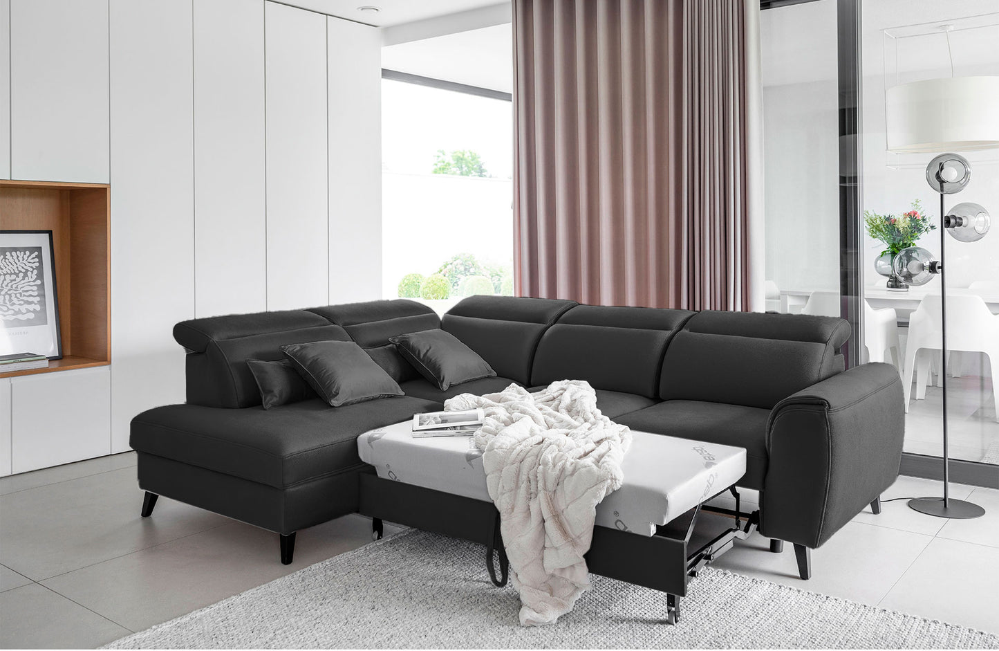 Lewostronny narożnik Noble w ciemnoszarej tkaninie Nube 06 z dekoracyjnymi poduszkami i ergonomicznymi zagłówkami. Stylowy narożnik do nowoczesnych wnętrz inspirowanych stylem modern, soft loft i minimalistycznym designem.