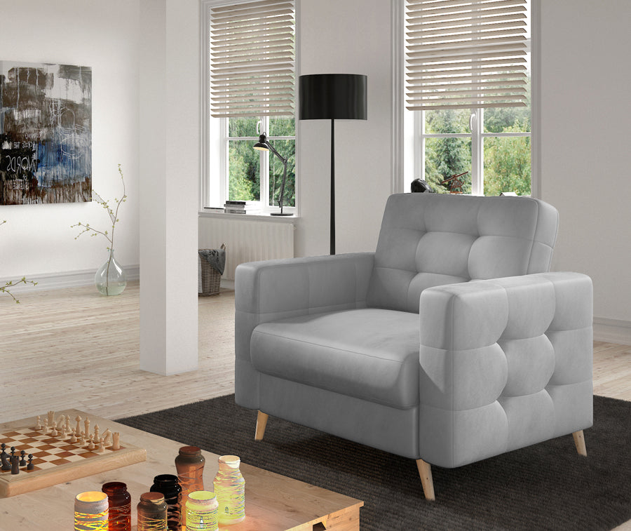Fotel Asgard w kolorze Monolith 84 jasnoszary w nowoczesnym salonie, ustawiony przy stoliku kawowym na jasnym dywanie.