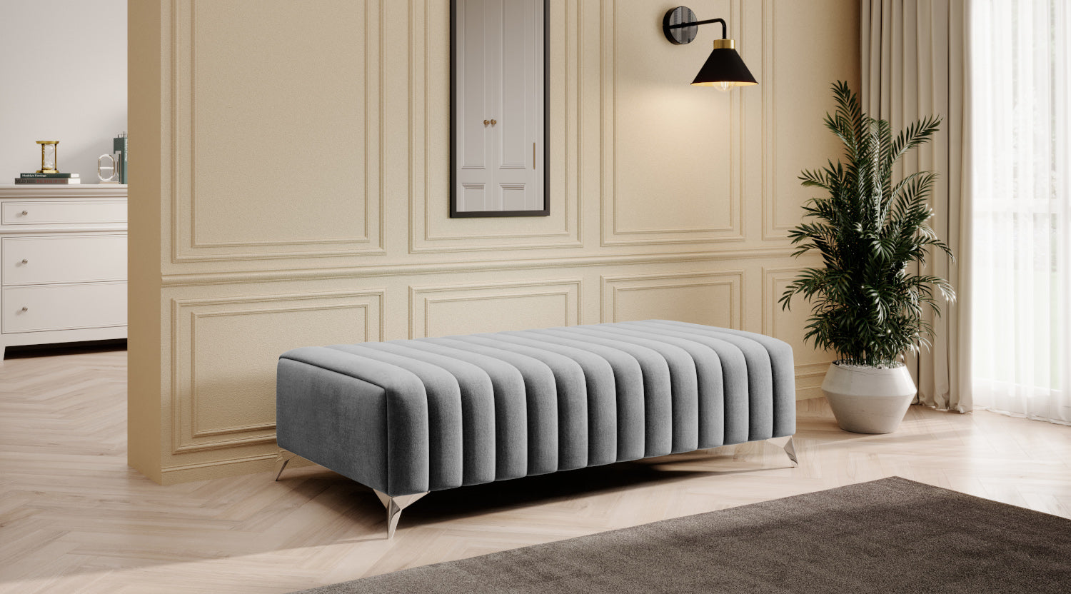 Gołębia pufa Laurence Nube 03 o podłużnej formie, z dekoracyjnymi przeszyciami i lekkimi srebrnymi nogami, idealna do sypialni, garderoby, salonu lub przedpokoju.