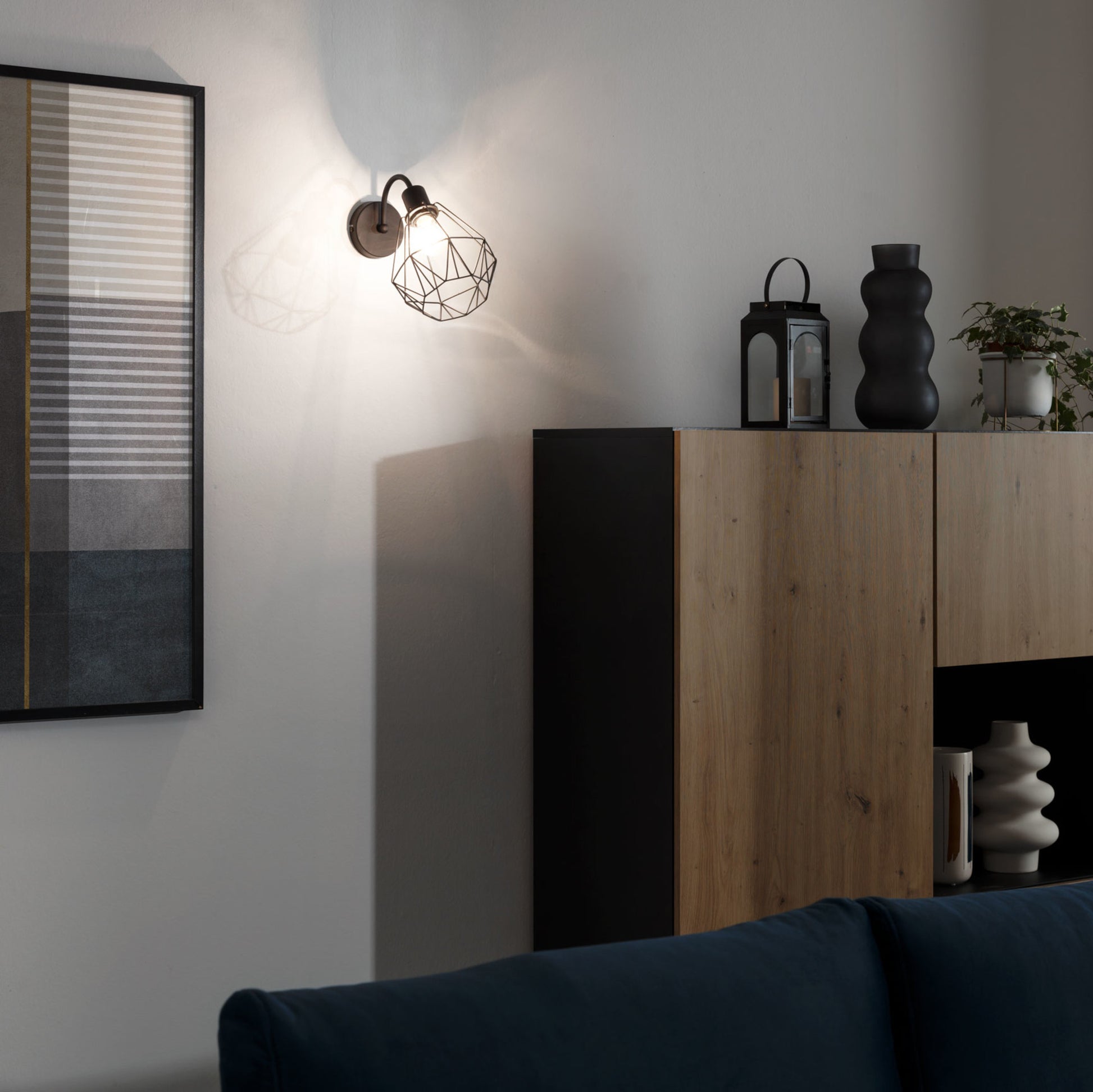 Kinkiet ścienny Bendinni czarny 19×26 cm – aranżacja w salonie przy zapalonym świetle