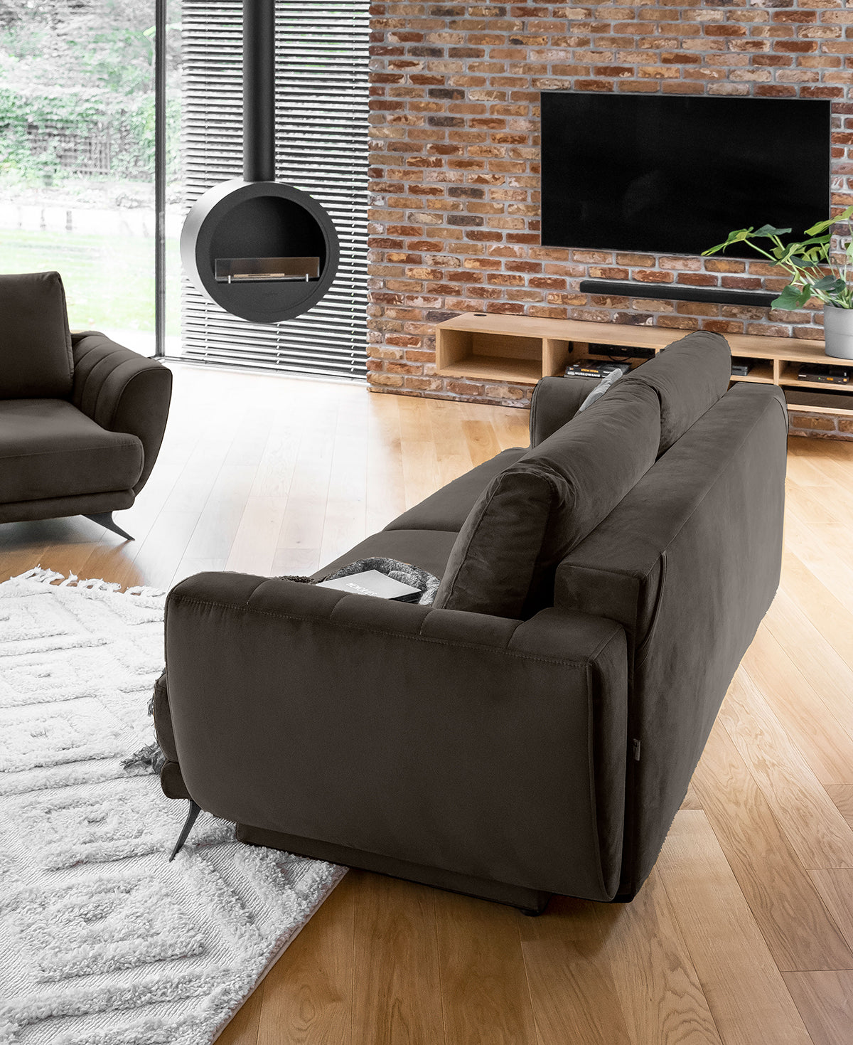 Ciemny zestaw sofa fotel pufa Megis Velvet do salonu w eleganckim stylu. Idealne rozwiązanie do nowoczesnych i minimalistycznych wnętrz.
