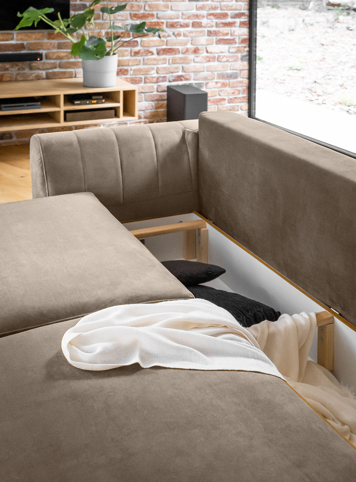 Sofa z fotelem i pufą Megis Sola w jasnobeżowej odsłonie. Minimalistyczna forma idealnie wpisuje się w styl nowoczesny i skandynawski.
