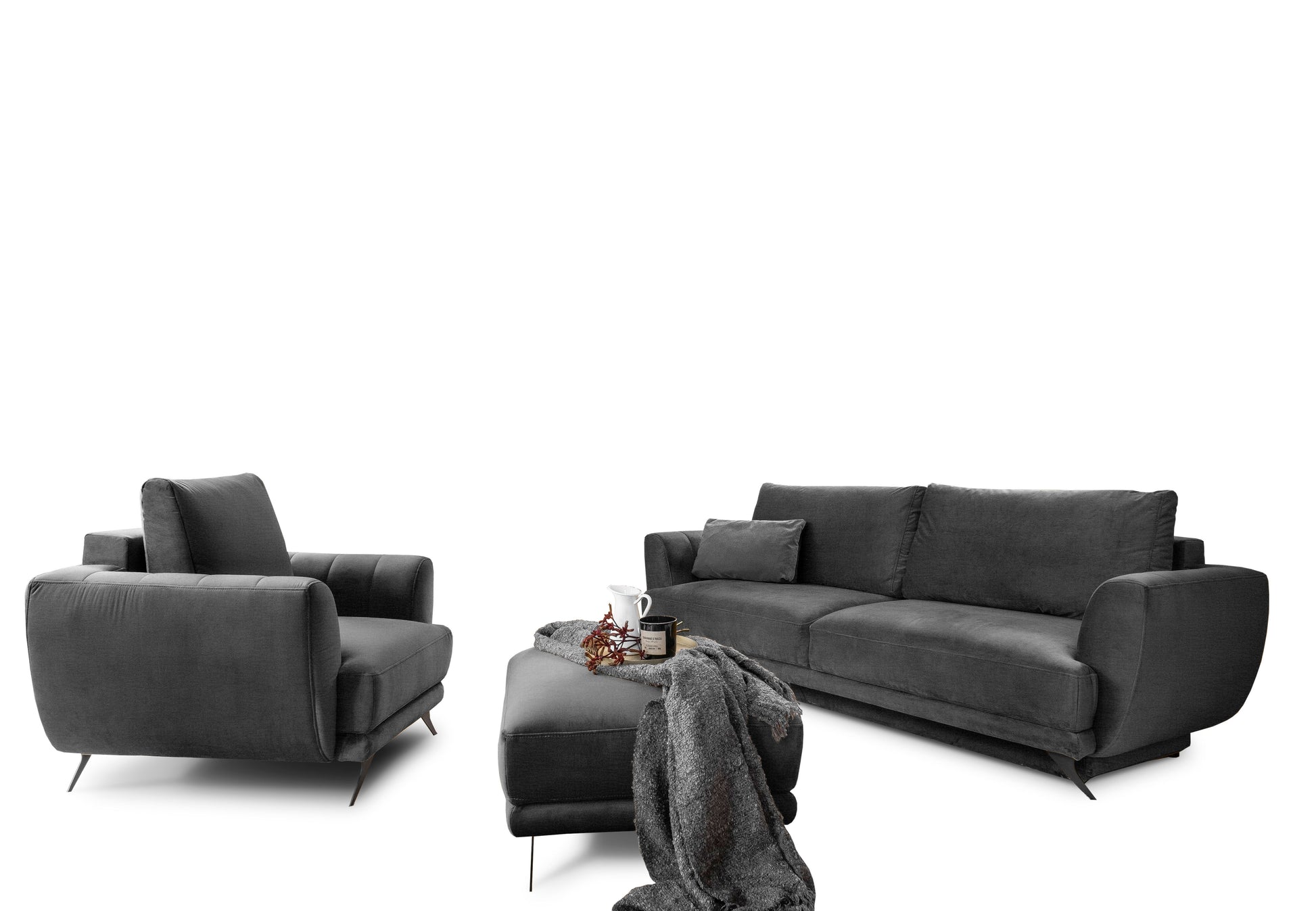 Ciemnoszary komplet wypoczynkowy Megis Velvetmat 06 z sofą, fotelem i pufą. Tkanina velvet dodaje elegancji i podkreśla nowoczesny charakter mebli.
