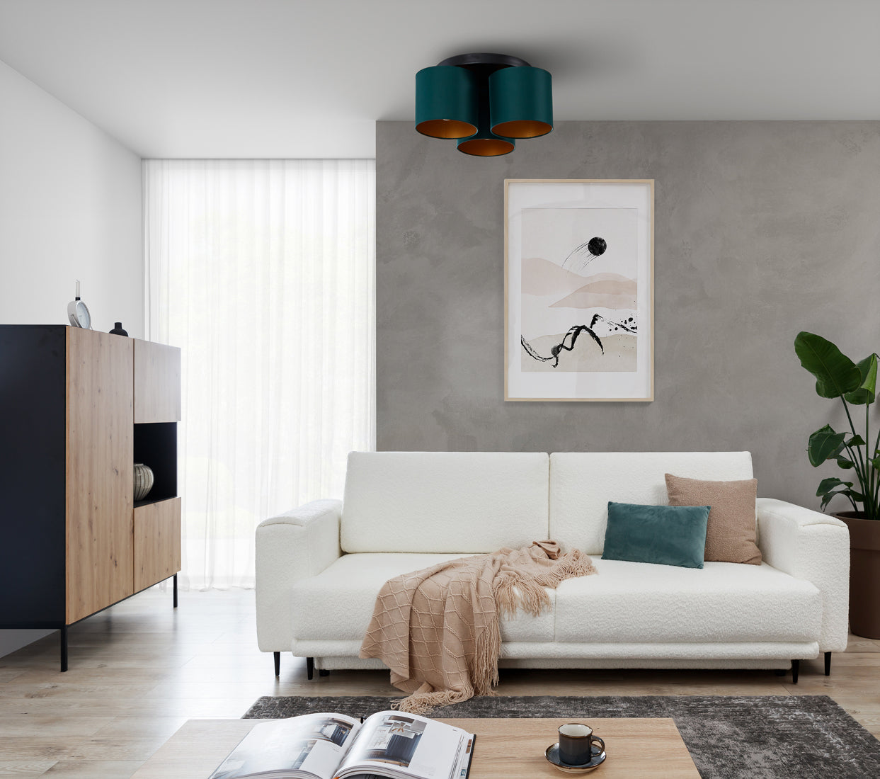Lampa sufitowa Vespillo 3 zawieszona nad białą kanapą w salonie z betonową ścianą, emitująca dzienne światło przez złote wnętrza zielonych abażurów.