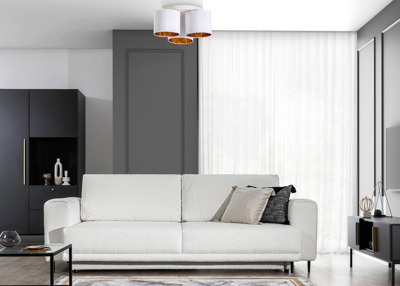 Lampa sufitowa Vespillo 3 zawieszona nad jasnobeżową sofą w salonie z czarno-szarą ścianą i dużym oknem, emitująca miękkie światło przez firanki.