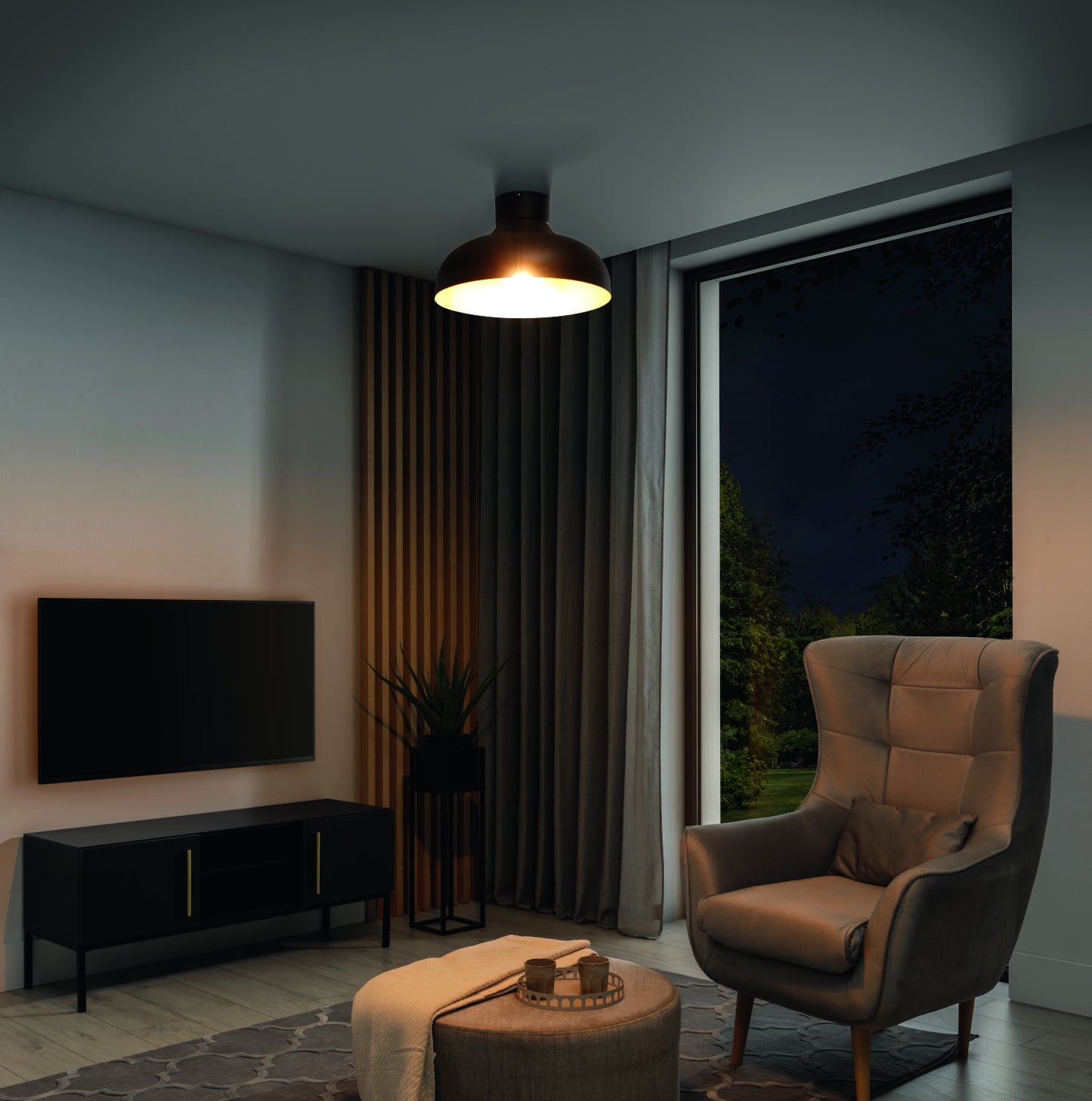 Lampa sufitowa Desolo o średnicy 40 cm w kolorze czarnym ze złotym wnętrzem, oświetlająca nowoczesny salon nocą.