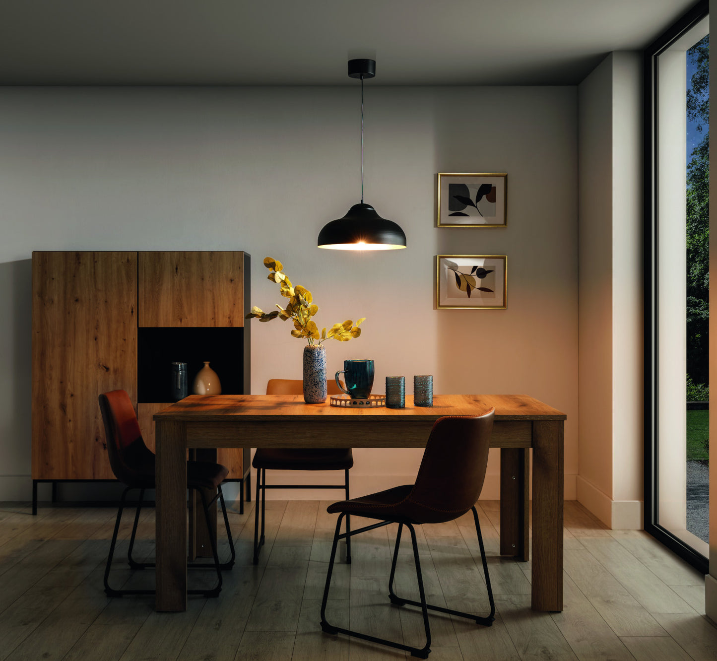 Lampa wisząca Desolo o wymiarach 40x130 cm w kolorze czarnym, oświetlająca stół w nowoczesnej jadalni z drewnianymi meblami.