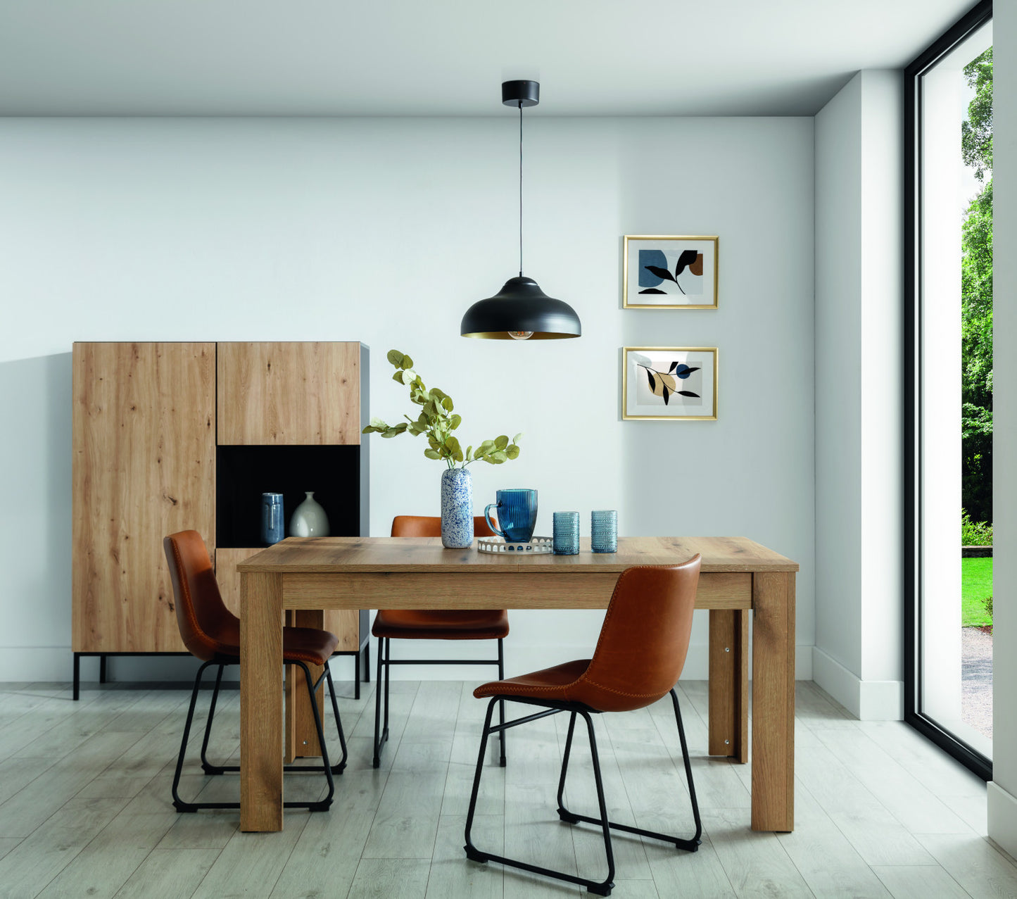 Lampa wisząca Desolo o wymiarach 40x130 cm w kolorze czarnym, zawieszona nad stołem w nowoczesnej jadalni z dużym oknem i drewnianymi elementami wystroju.