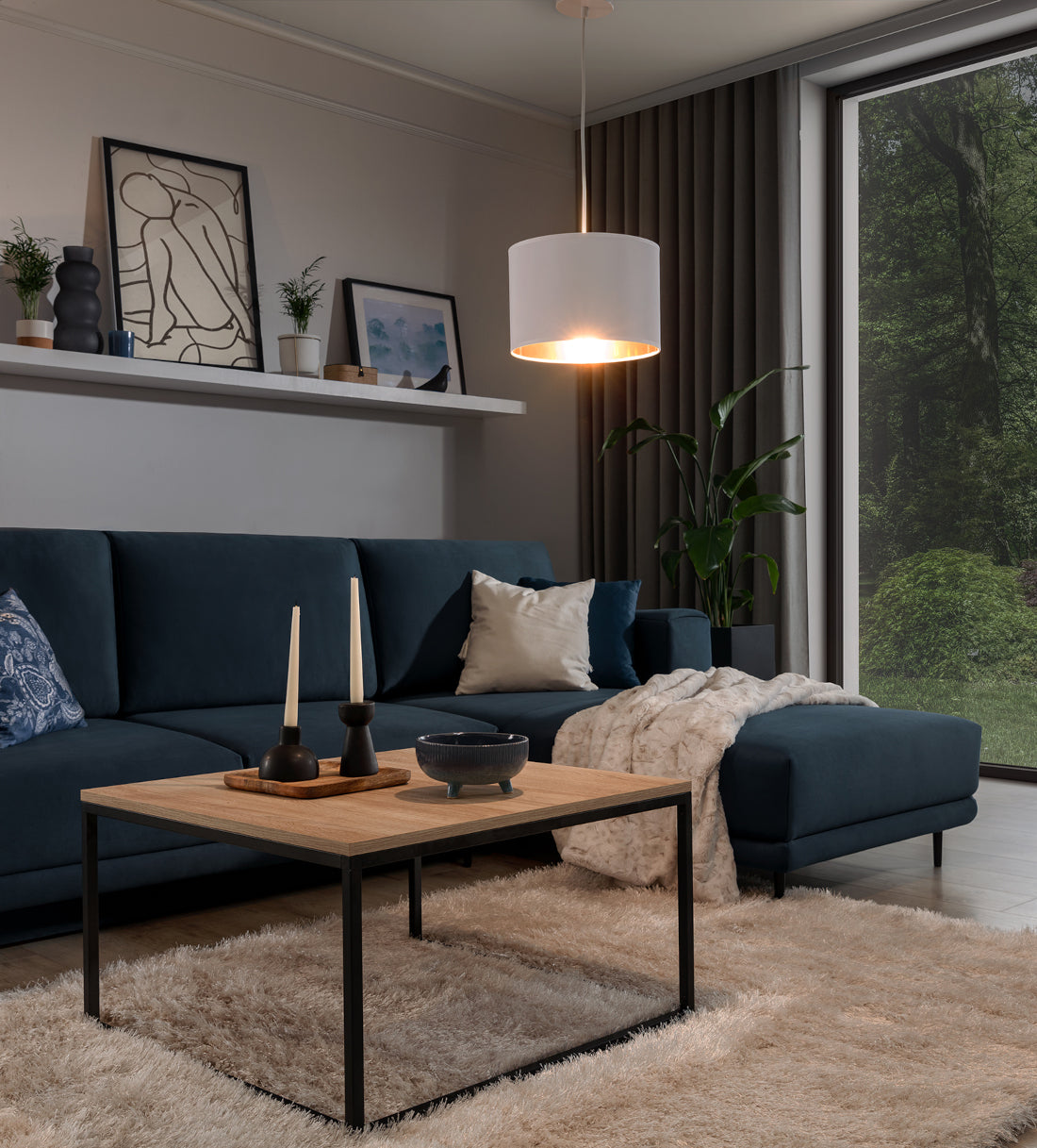 Włączona lampa wisząca Vespillo w wieczornej aranżacji salonu, rzucająca nastrojowe, złote światło na otoczenie i wykorzystana jako dekoracyjny akcent.