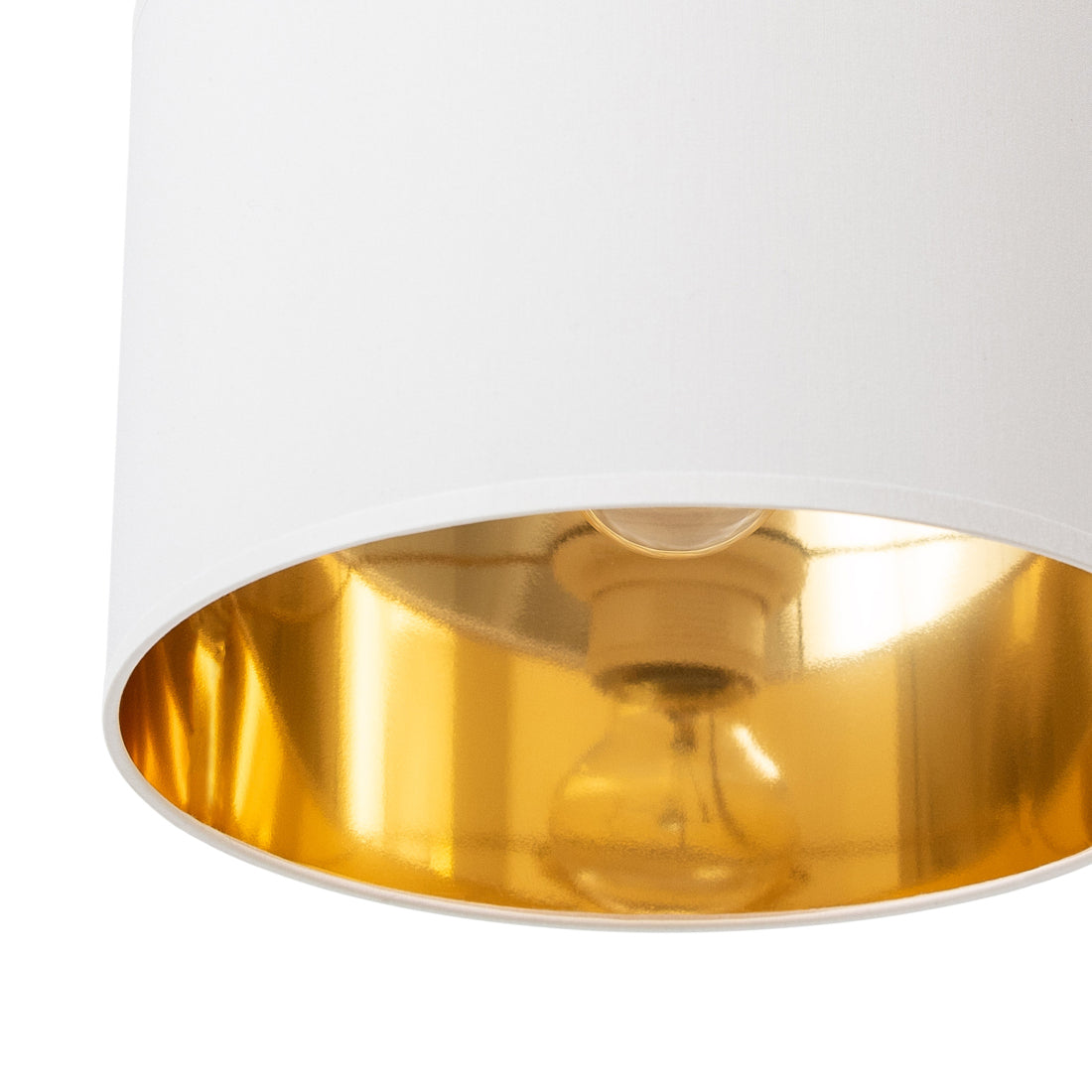 Zbliżenie na biały, cylindryczny abażur lampy wiszącej Vespillo, pokazujące gładką tkaninę oraz odbijające światło, złote wnętrze klosza.