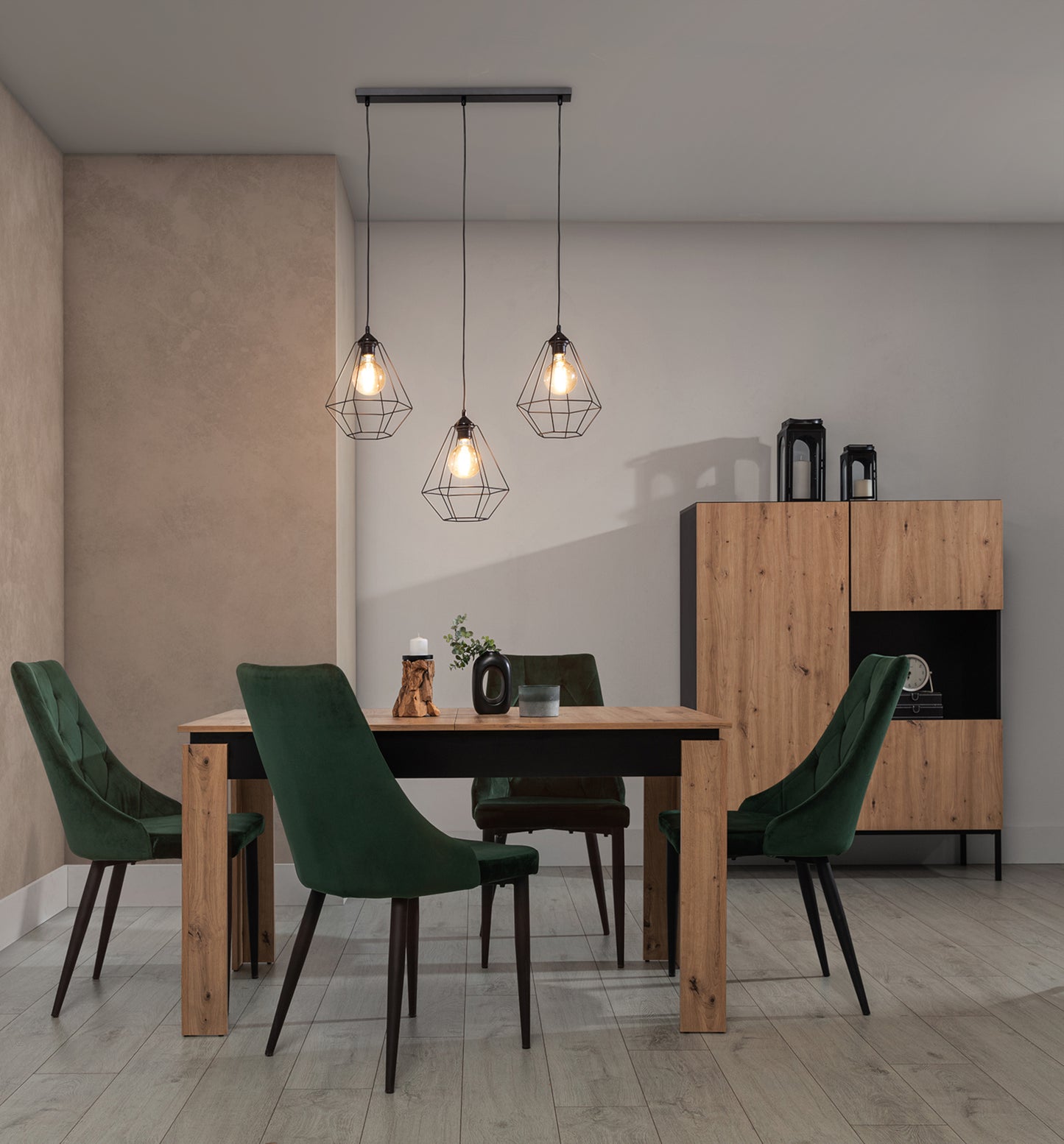 Lampa wisząca Brevitas 70x110 cm – aranżacja z oświetleniem – lampa z trzema zapalonymi żarówkami, tworząca przytulną atmosferę w nowoczesnej jadalni z drewnianymi i zielonymi akcentami.
