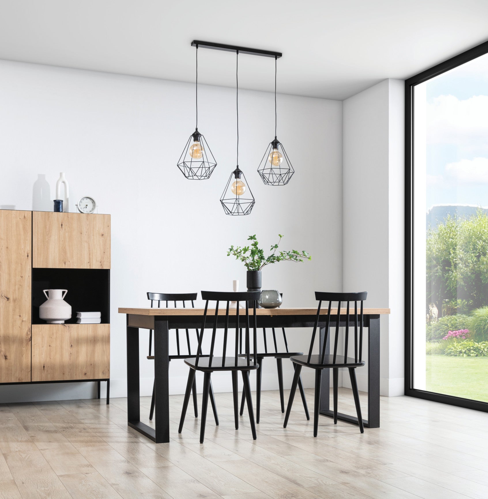 Lampa wisząca Bendinni czarna 74x110 cm w aranżacji jadalni – potrójne zwisy nad stołem