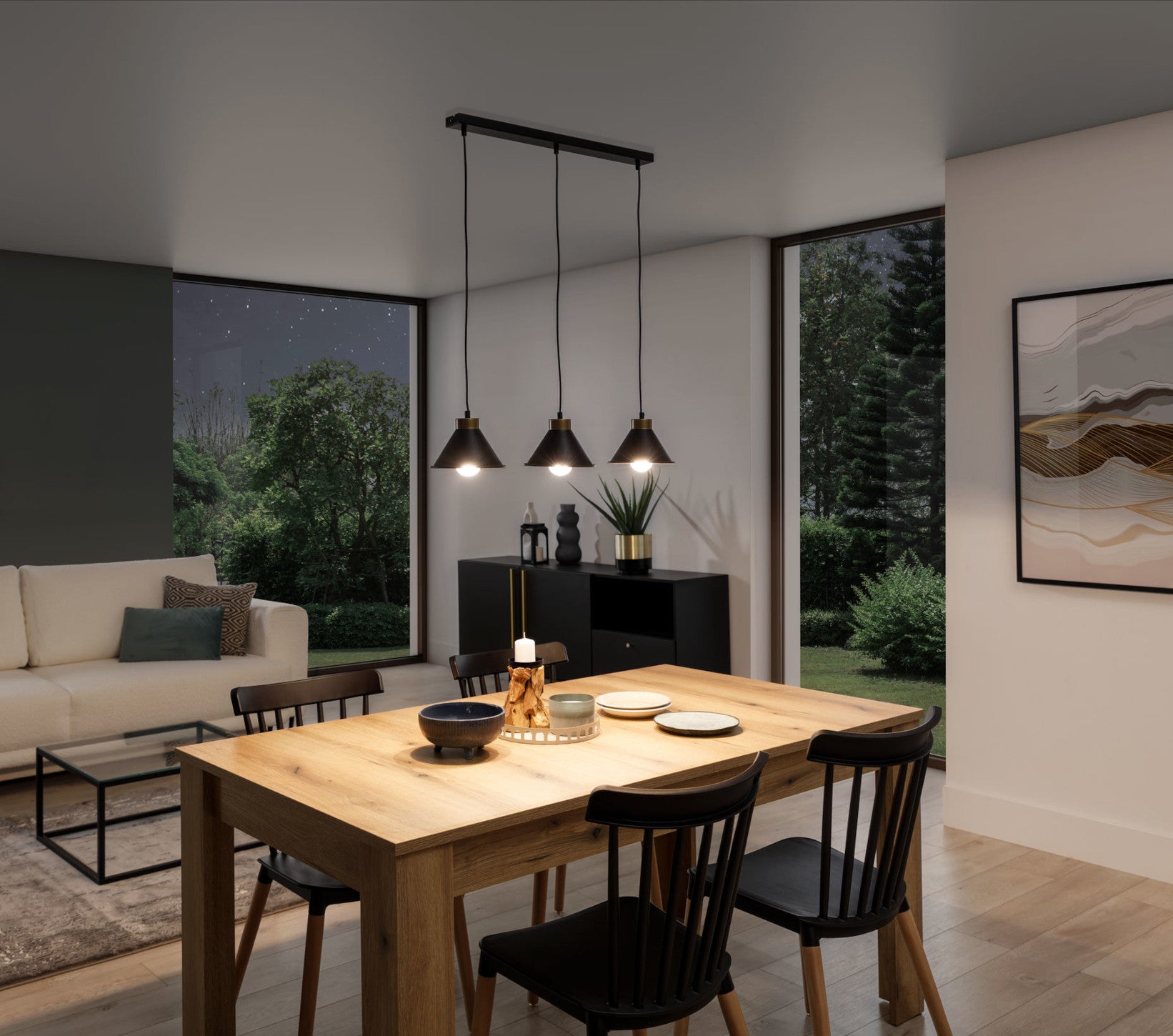 To samo wnętrze salonu po zmroku, z włączoną czarną lampą Detmer 3 emitującą ciepłe światło, nad drewnianym stołem i czarną komodą przy dużym oknie.