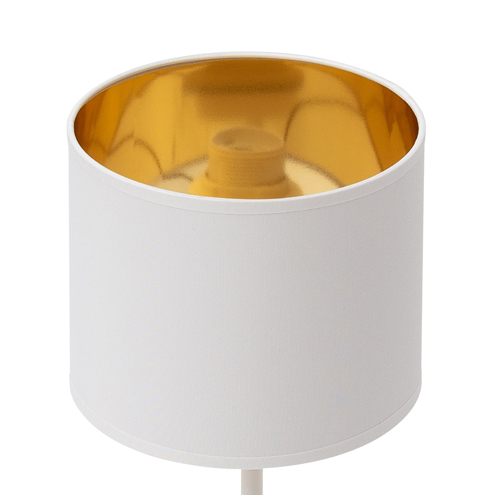 Zbliżenie na abażur lampki Vespillo: gładka, biała tkanina z lśniącym, złotym wnętrzem, bez widocznej żarówki ani podstawy.
