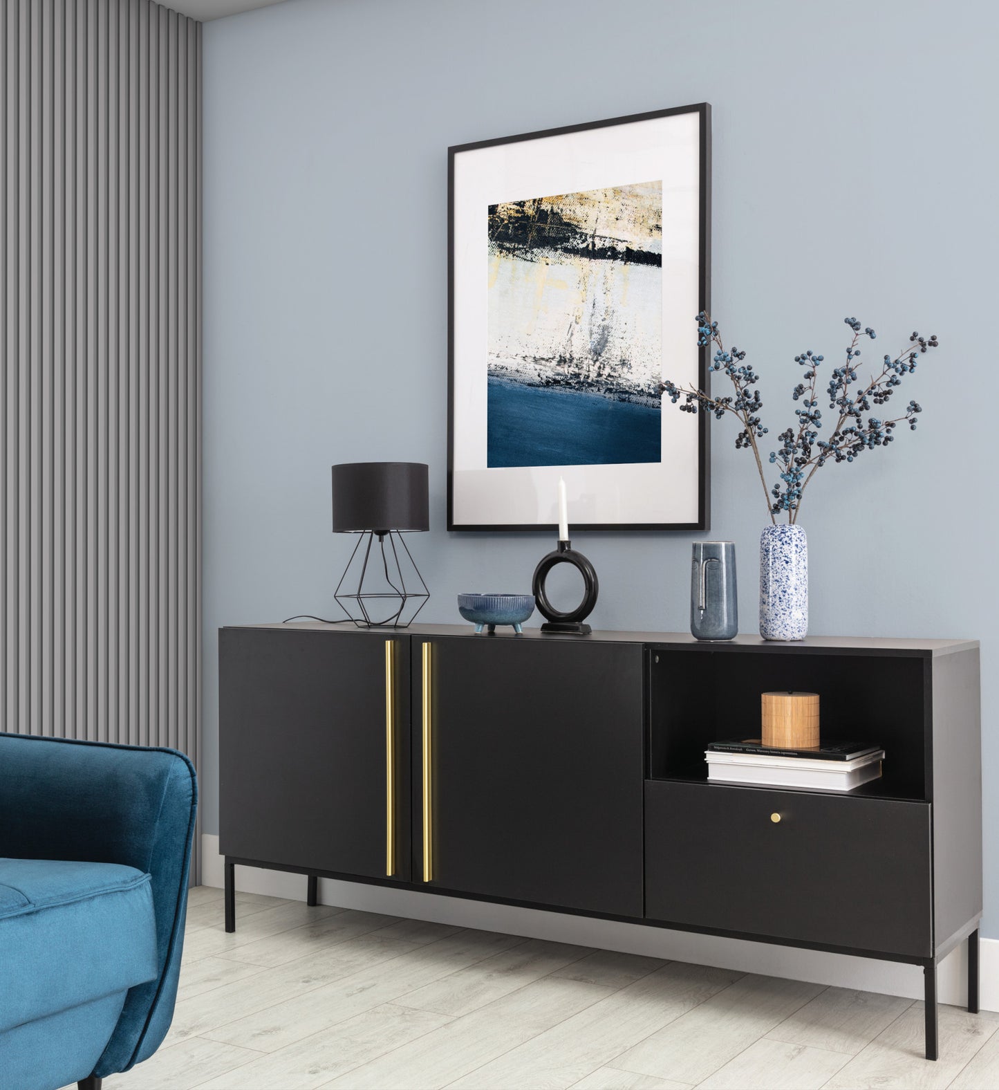 Lampka nocna Brevitas 25x44 cm – aranżacja w salonie – czarna lampka loftowa ustawiona na stoliku pomocniczym obok granatowej sofy w nowoczesnym wnętrzu.