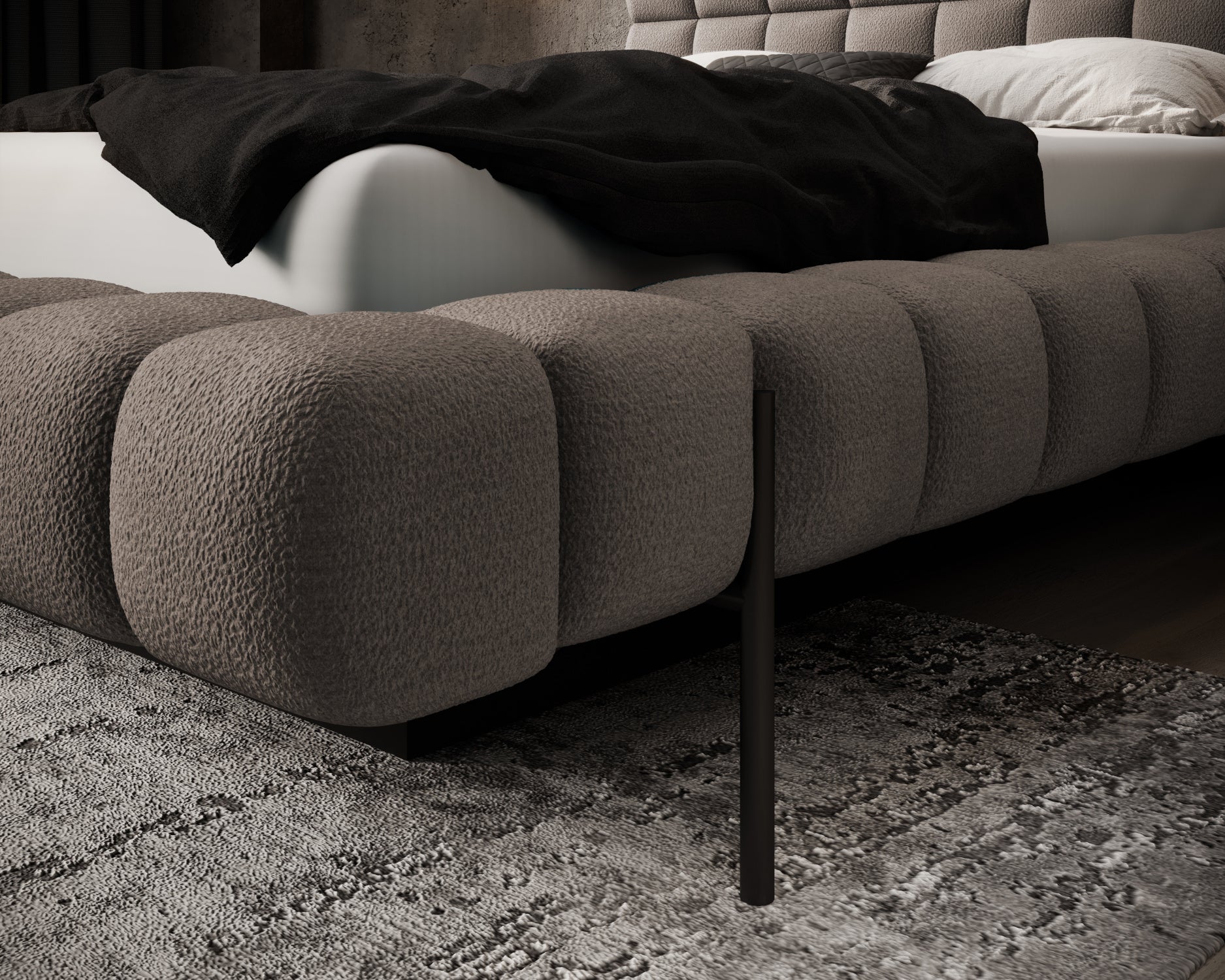 Zbliżenie na narożnik łóżka Magentta w tkaninie Amore 20 jasnobrązowy, z miękkim pikowaniem i metalową nogą w eleganckiej sypialni.