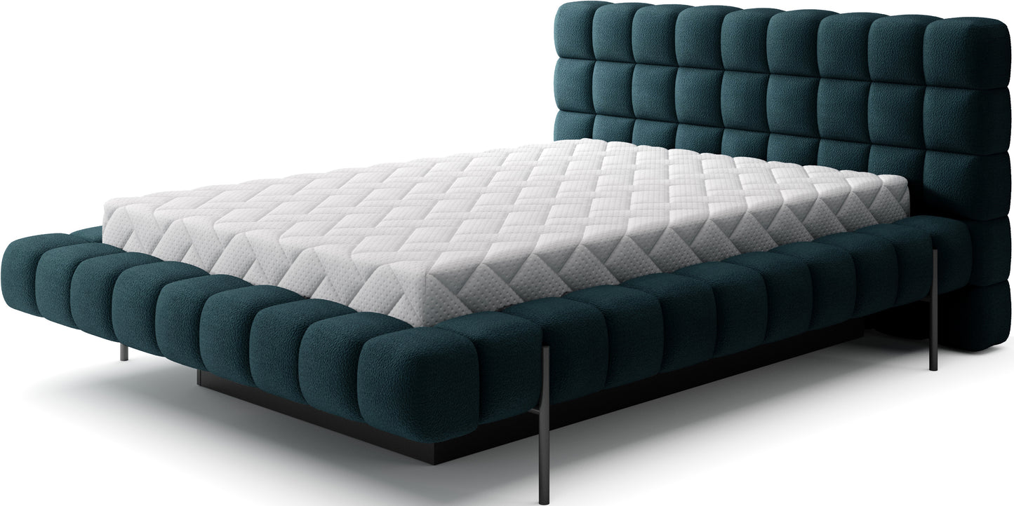 Łóżko Magentta tapicerowane w tkaninie Amore 40 granatowy z wysokim pikowanym zagłówkiem i czarnymi metalowymi nóżkami.