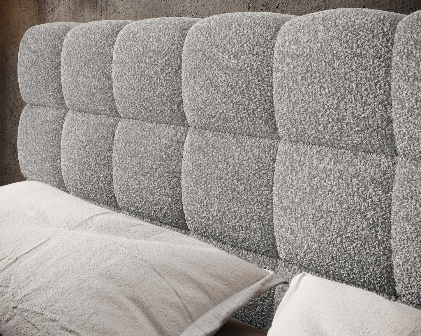 Zbliżenie na pikowany zagłówek łóżka Magentta tapicerowany miękką, jasnoszarą tkaniną Royal 04 o wyrazistej strukturze boucle