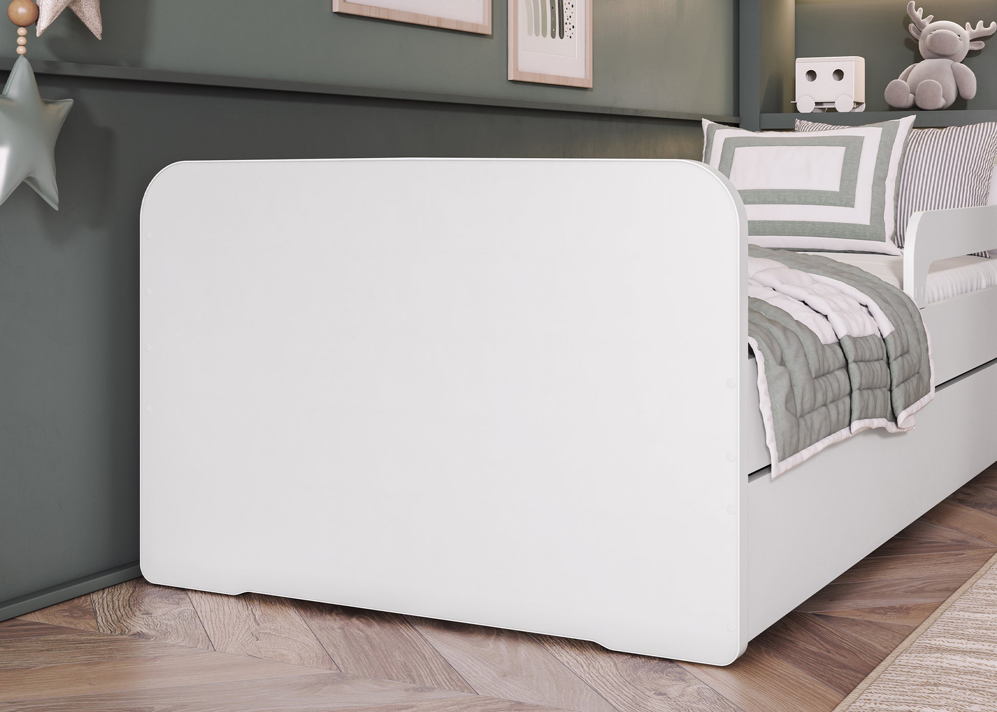 Boczne ujęcie łóżeczka Duuli 160 cm w bieli, zbliżenie na zaokrąglony panel boczny w aranżacji dziecięcego pokoju z zabawkami i dekoracjami.