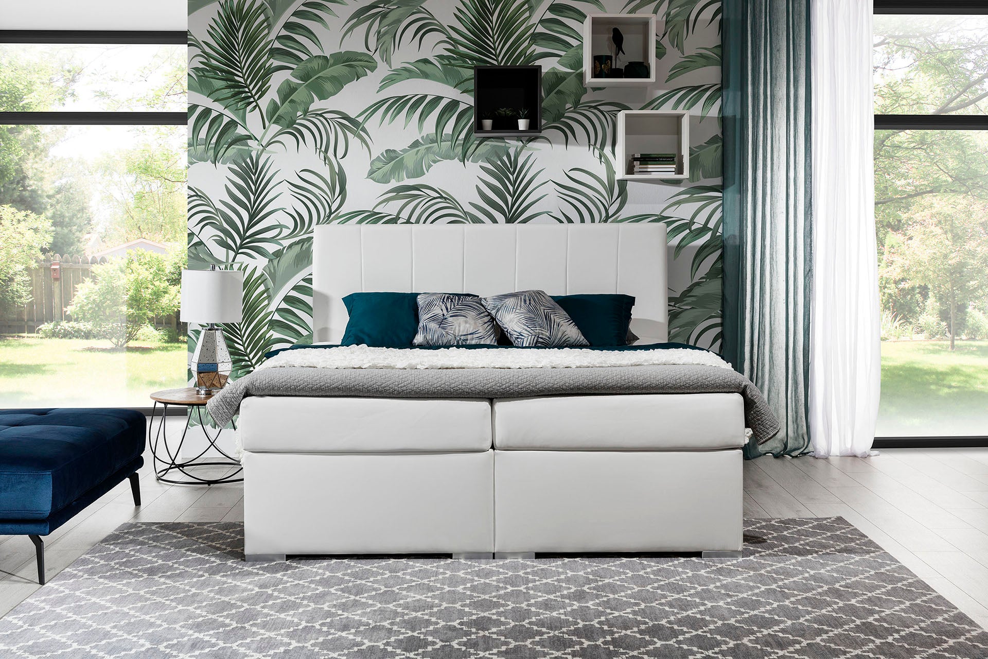 Łóżko Bolero 140x200 Soft 17 biały ustawione na tle panoramicznego okna z zimowym krajobrazem w tle.