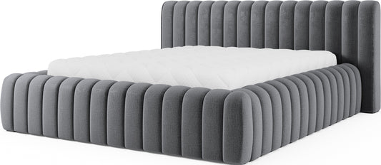 Łóżko Carilla tapicerowane tkaniną Monolith 97 w odcieniu ciemnoszarym z pionowym pikowaniem i wysokim zagłówkiem