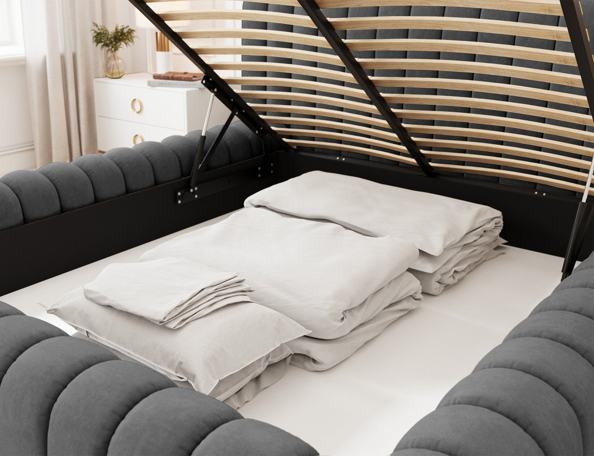 Otwarte łóżko Carilla Sola 06 ciemnoszary z podniesionym stelażem i pojemnikiem na pościel, widoczne uporządkowane tekstylia